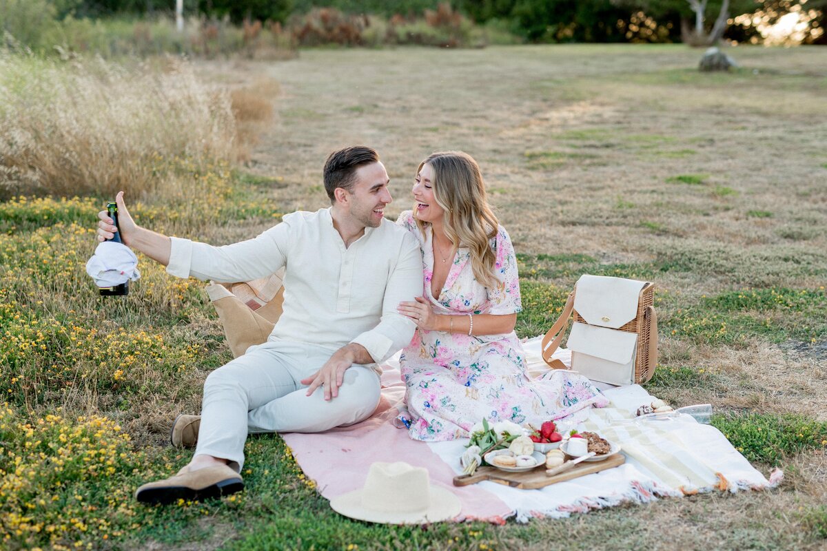 Couple laughing together during romantic picnic setup