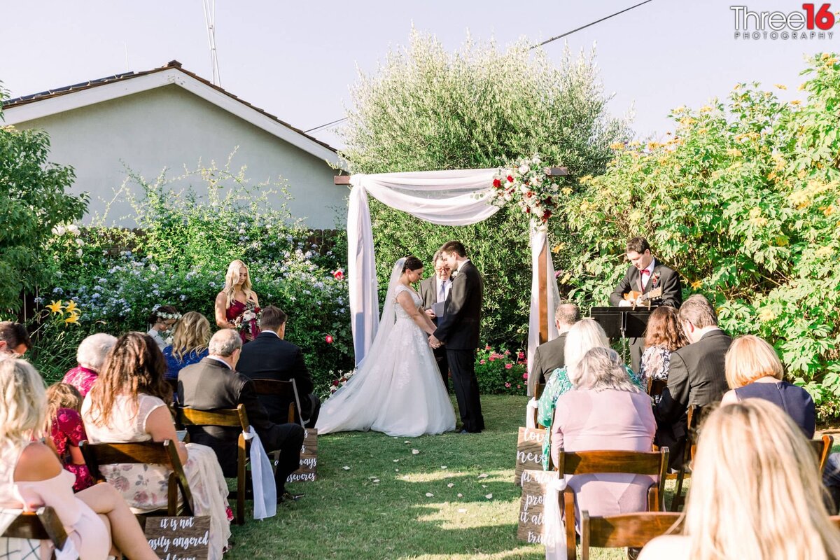 Heads are bowed at a backyard micro wedding