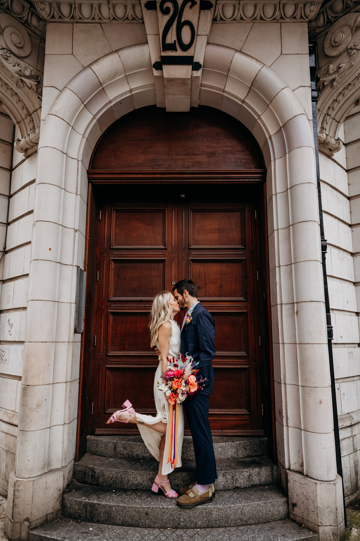 Leeds city wedding couple by door after wedding at Leeds Civic Hall