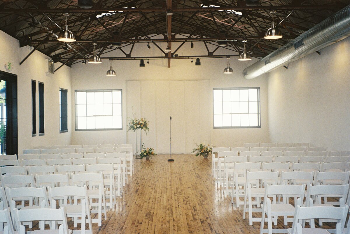 A beautiful wide shot of the wedding ceremony at The Tinsmith, captured on film, showcasing the elegant setting and joyful atmosphere of the special day in Madison.