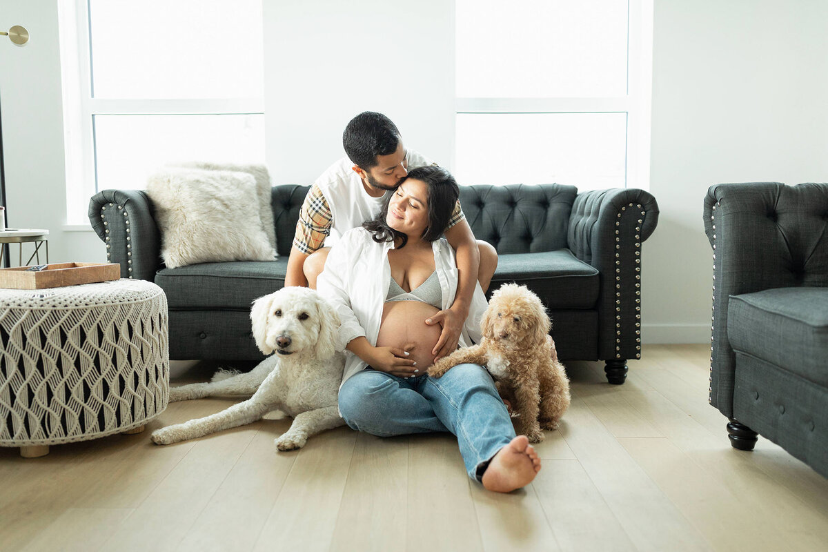 Indoor maternity photography session in DC with couple on the floor with their dogs