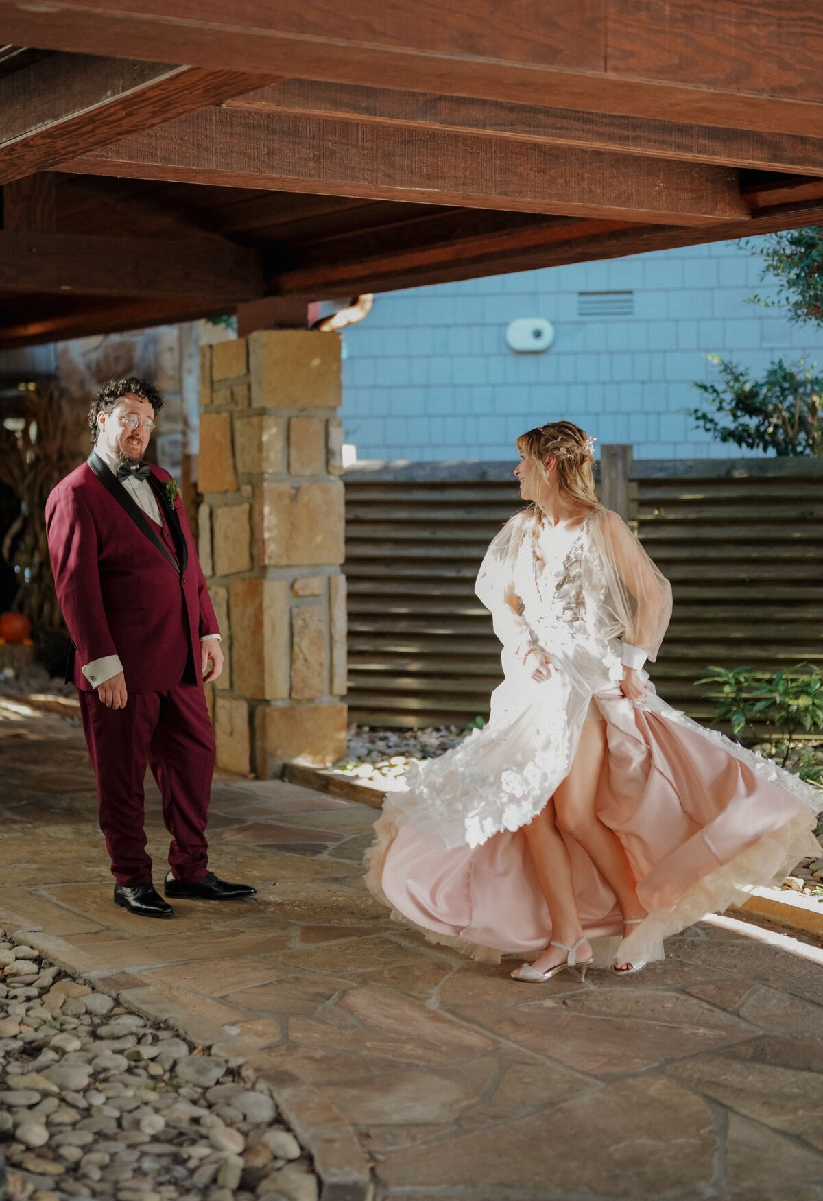 Bride twirling in her wedding dress, groom watching her after first look