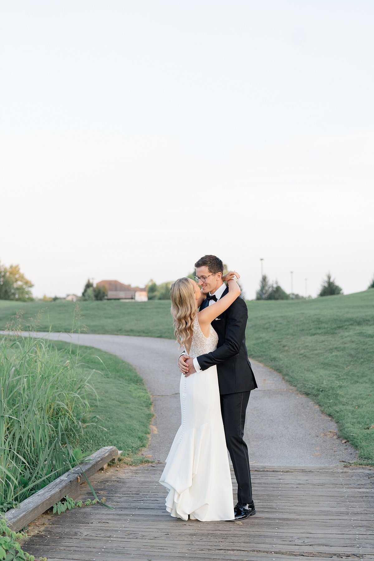 Columbus wedding  photographer captures bride and groom embracing and dancing together on a path on a gold course at the Pinnacle