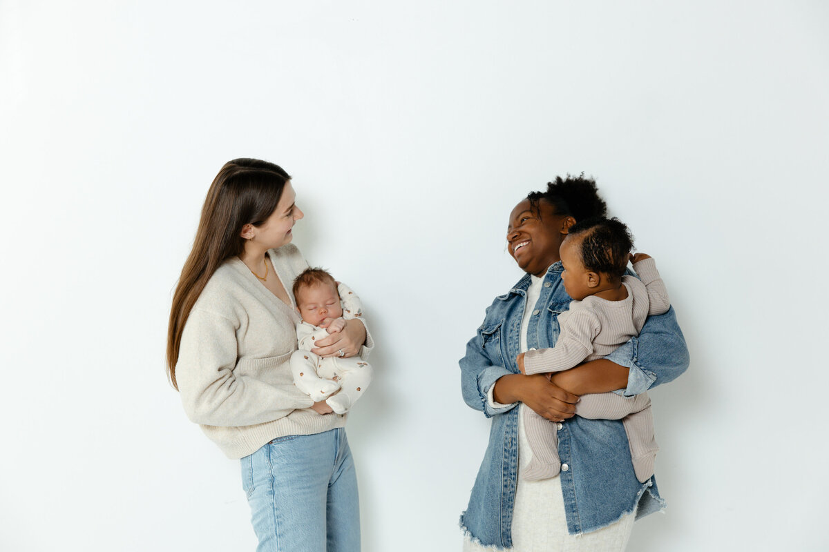 tow moms holding babies