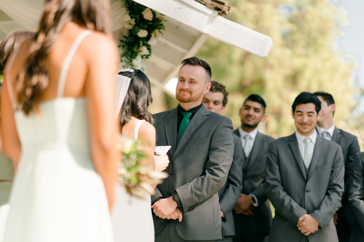 a lower angled photo of groom smiling at bride