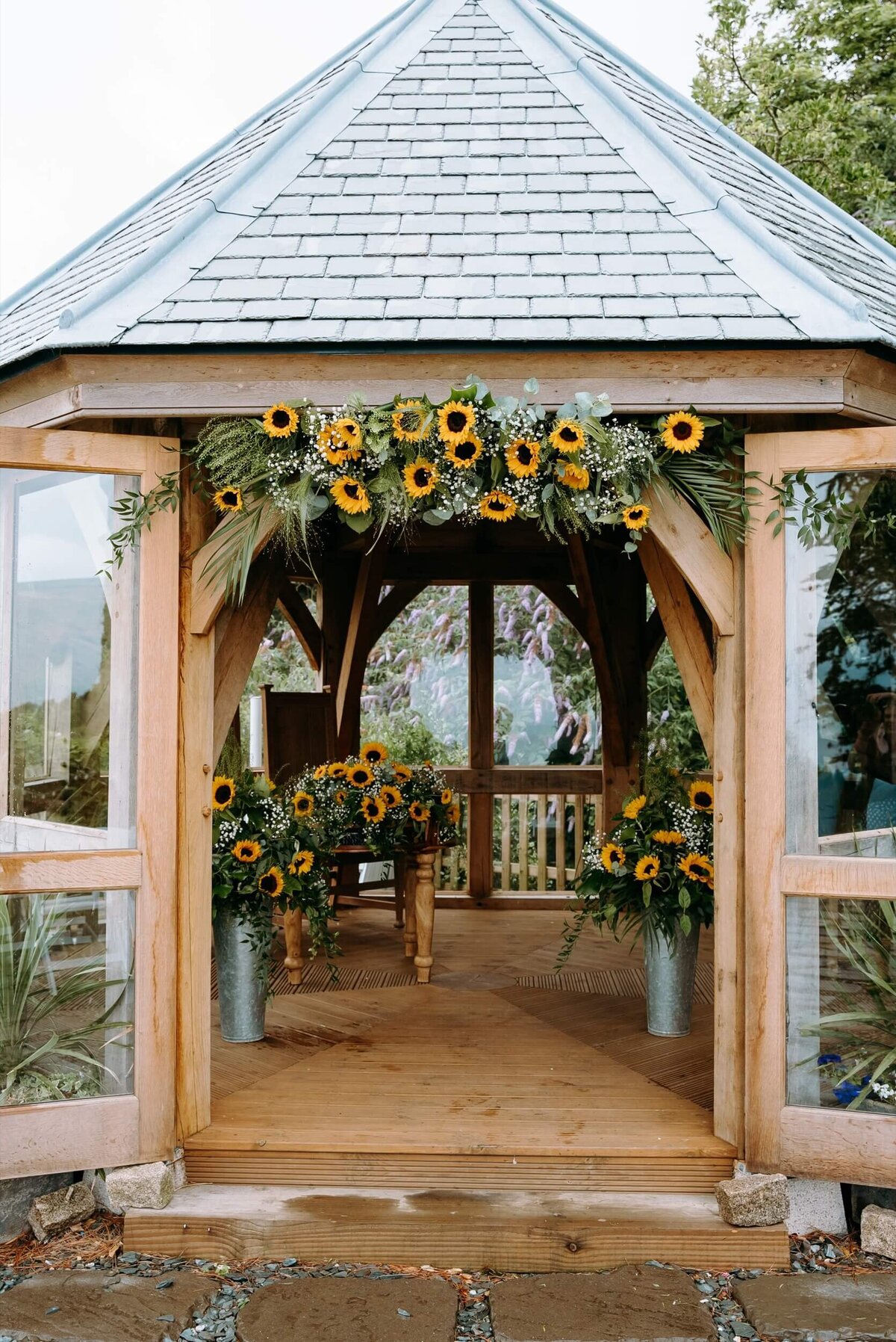 A wooden gazebo with sunflowers on it