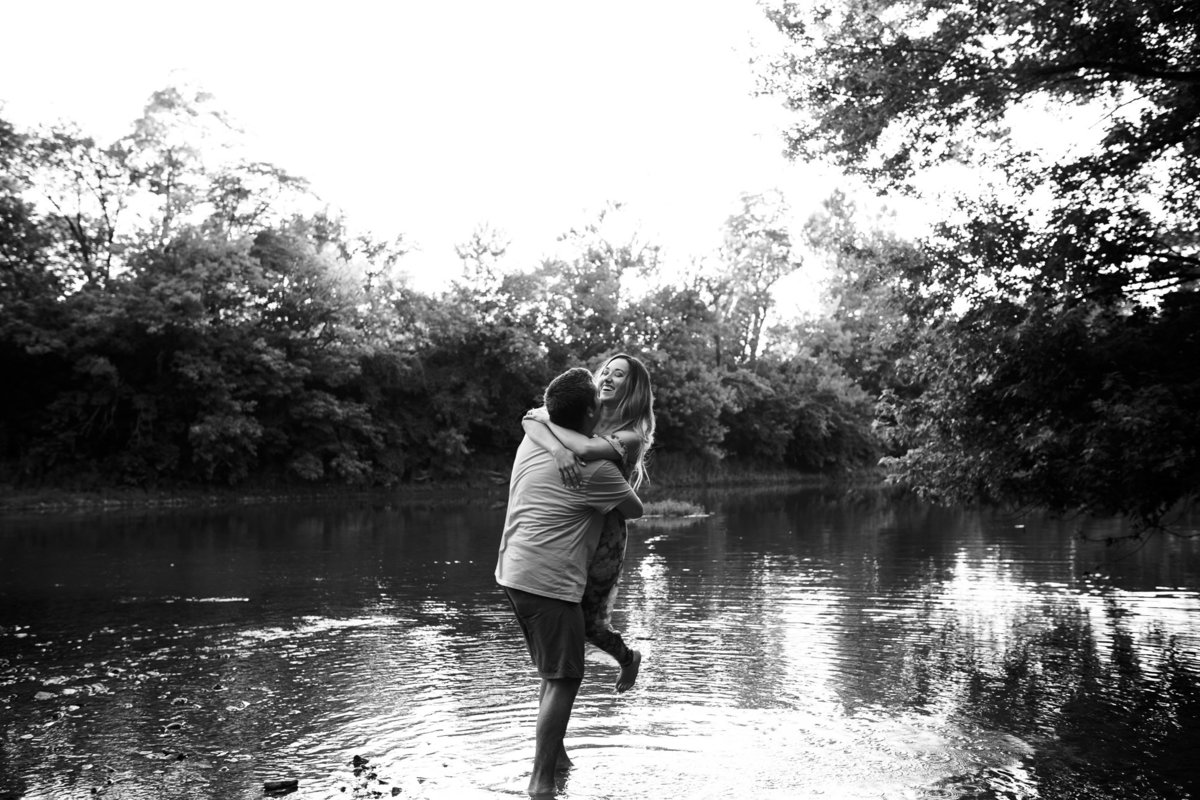 Couple plays in the water at their engagement session