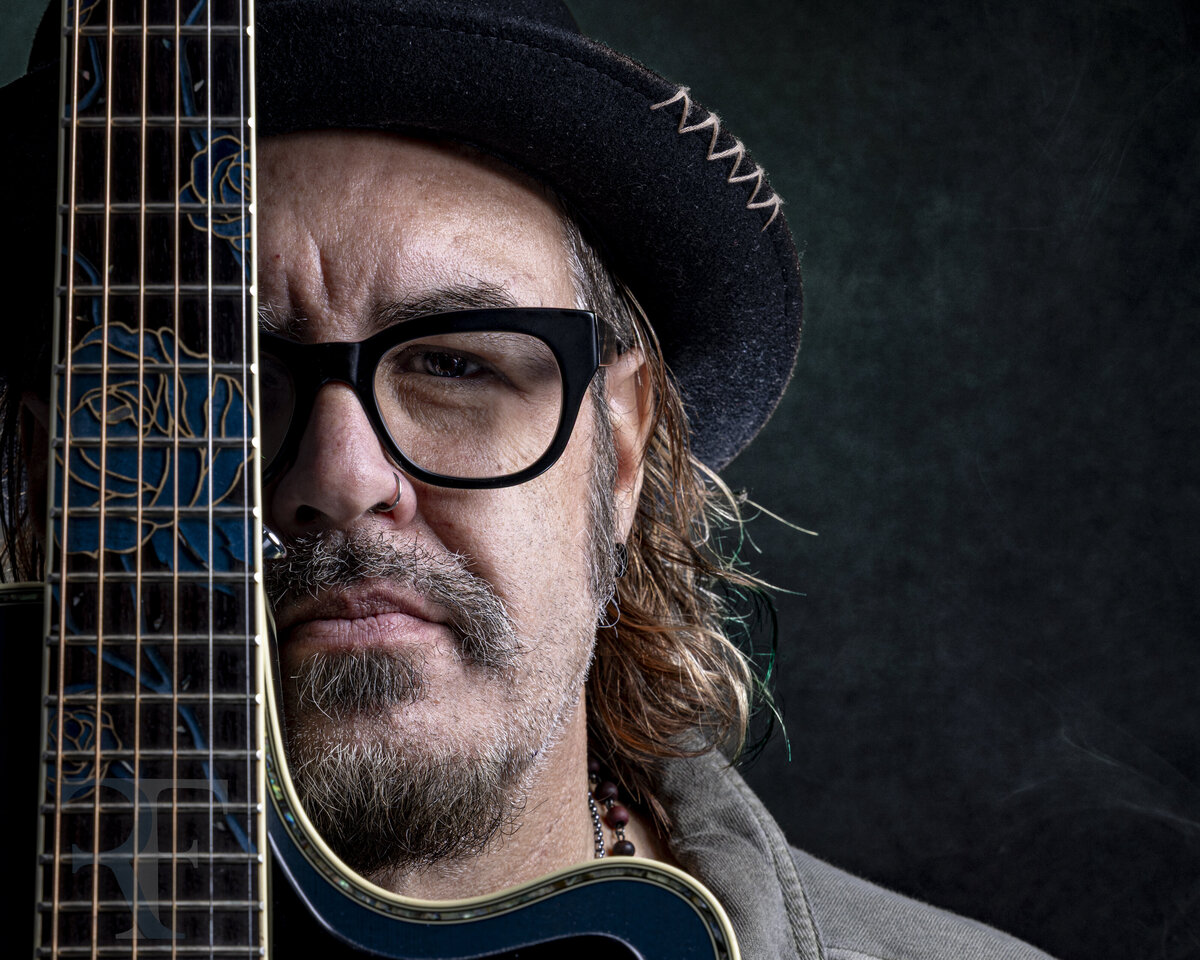 Creative headshot in CT of a man with glasses, a black hat, and long wavy hair, photographed with moody lighting for branding portraits and headshots in CT and MA by Rob Faber Photography.