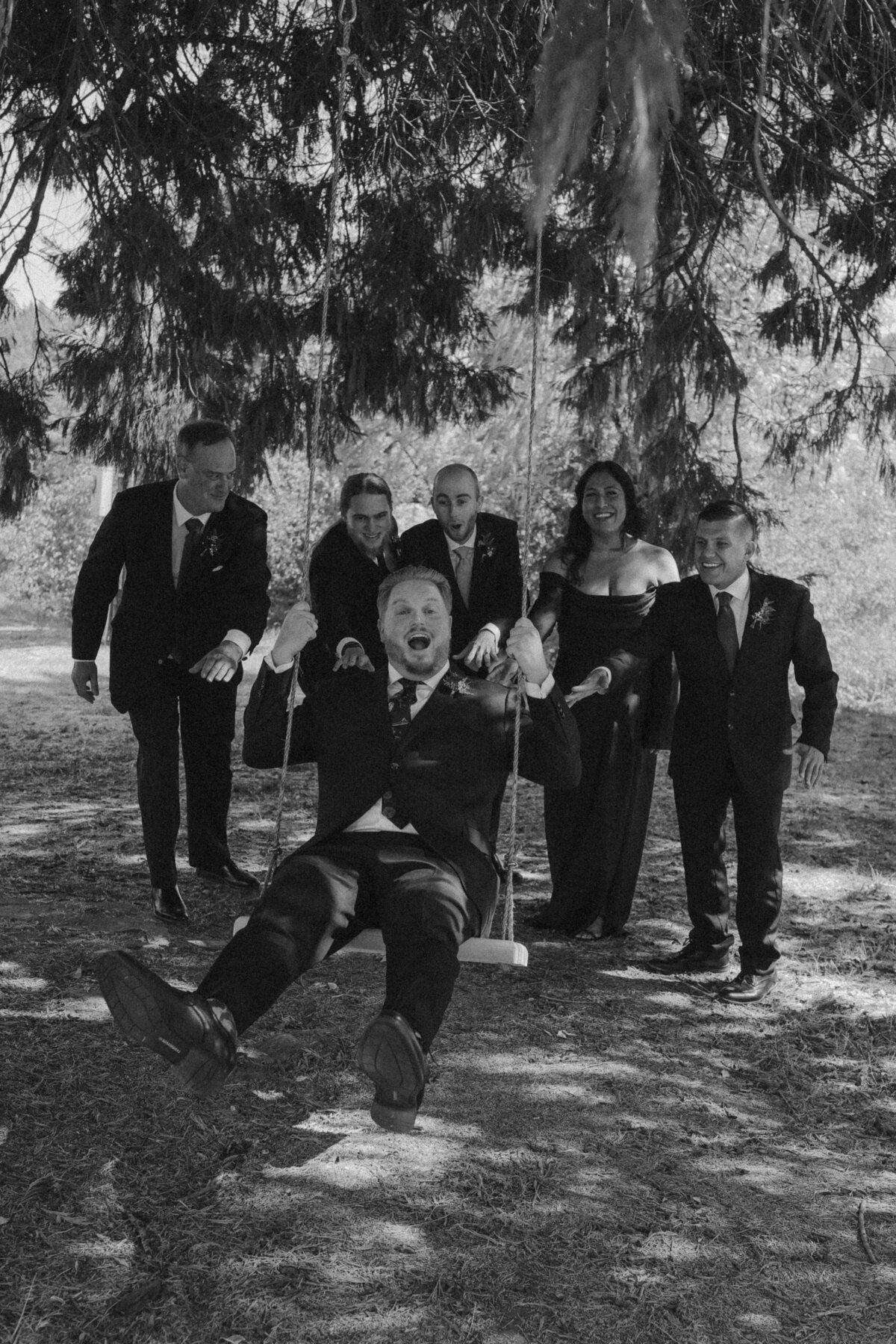 Groomsmen Laughing and Pushing Groom on a Swing | Candid Oregon Wedding Photographer