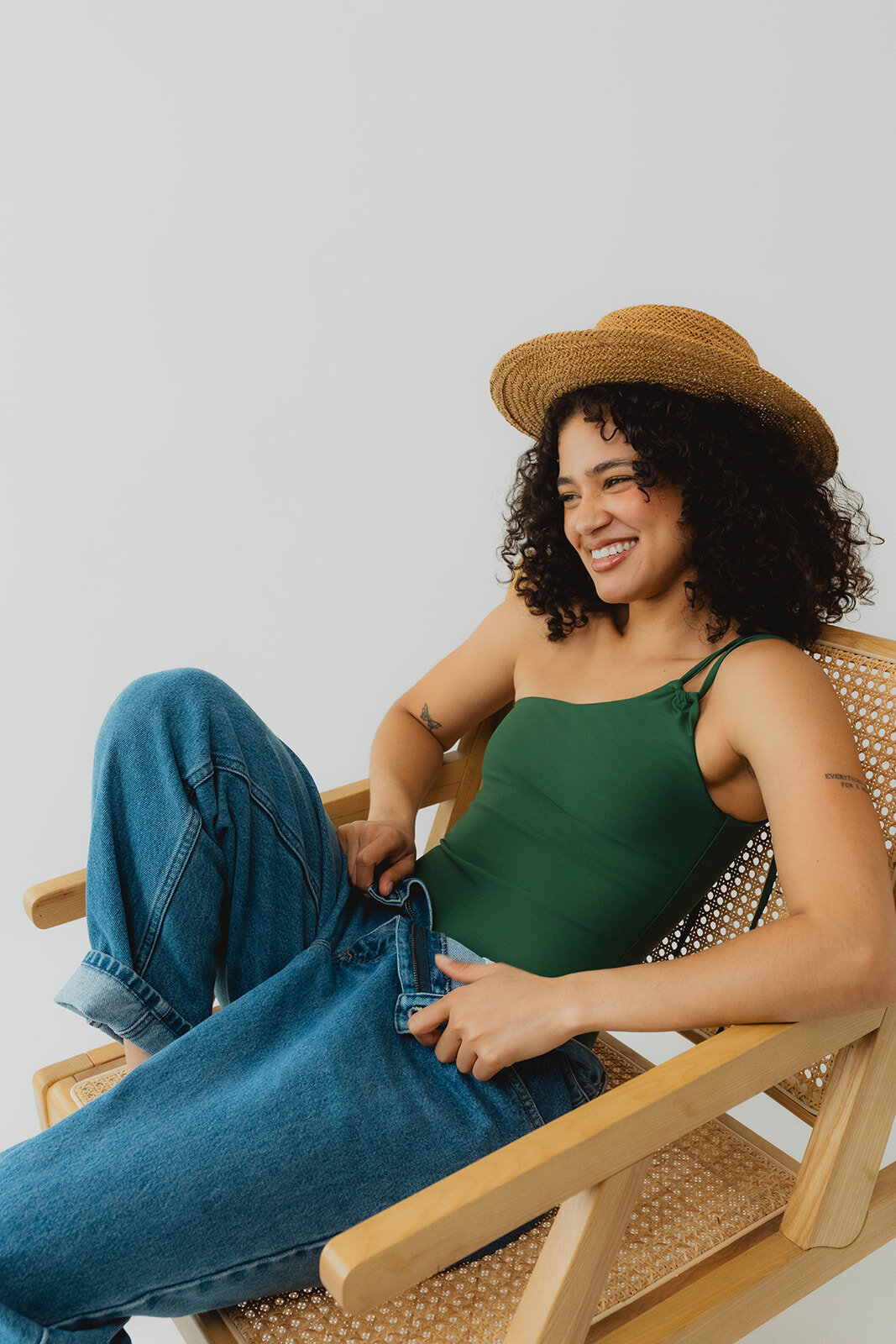 woman modeling sustainable swimwear smiling in a chair