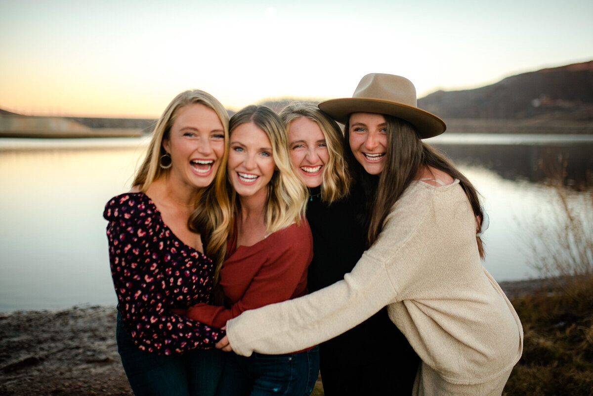 sisters and bestfriends hugging on the shores of horsetooth resevoir