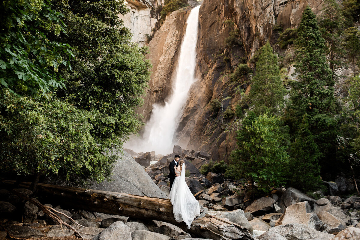 A bride and groom enjoy a quiet moment at lower yosemite falls