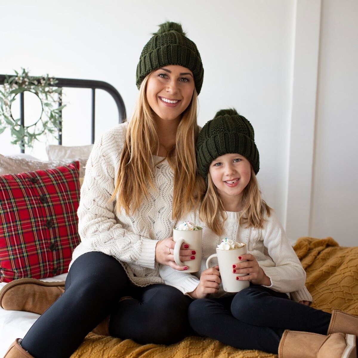 Colorado wedding and boudoir photographer and her daughter sitting on a bed with mugs