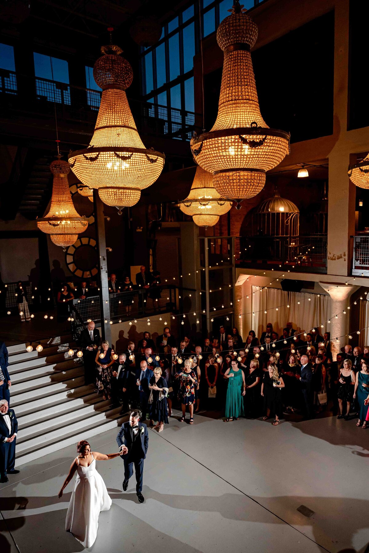 Bride and groom dance surrounded by chandelier's at Artifact Events  