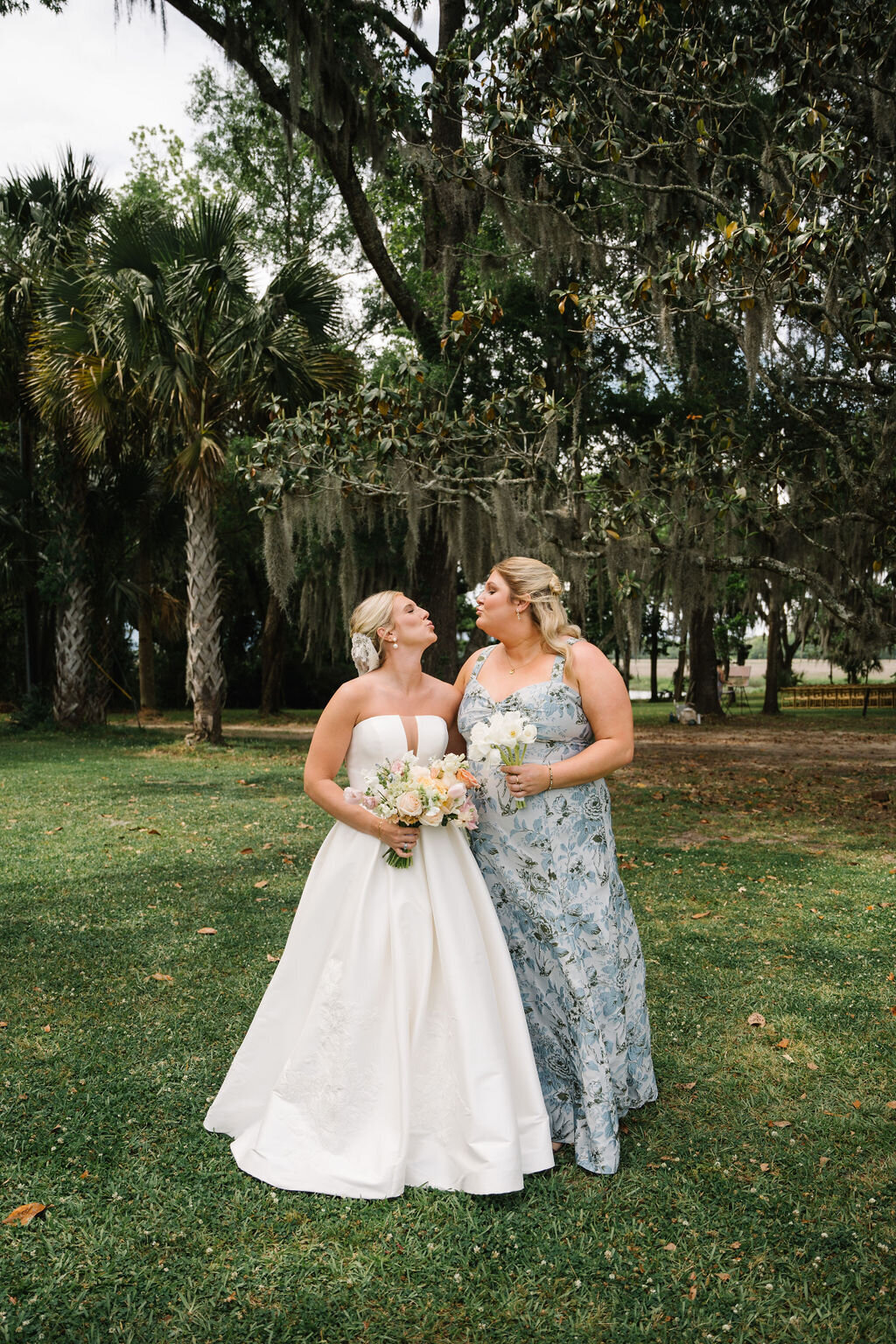 Bride and her bridesmaid making kiss faces at each other