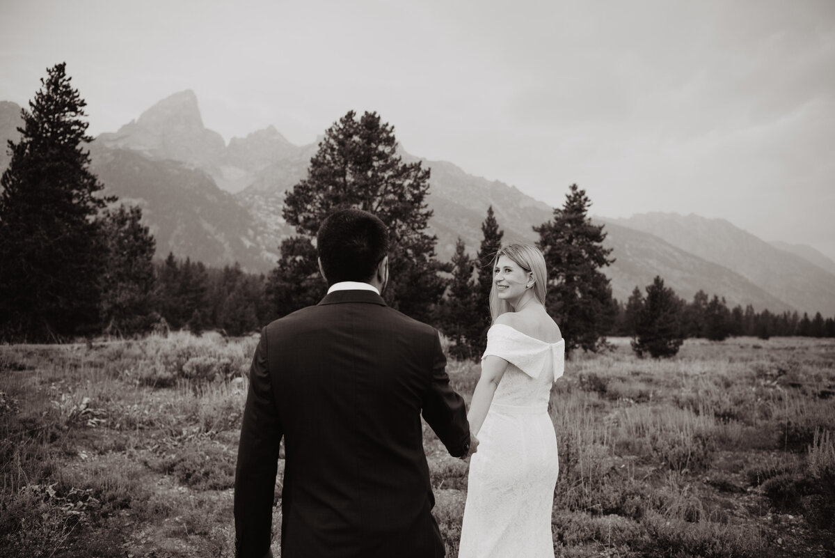 Photographers Jackson Hole capture bride leading groom into park