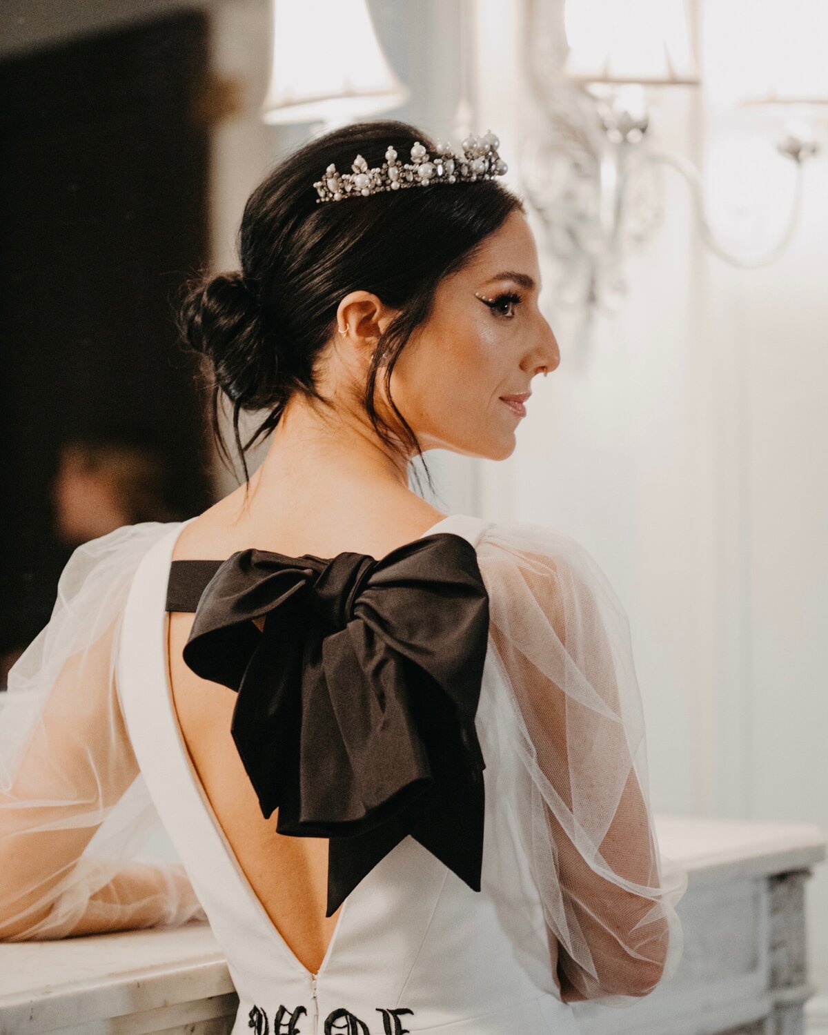 Bride with dark hair wearing hair in low bun with a pearl crown