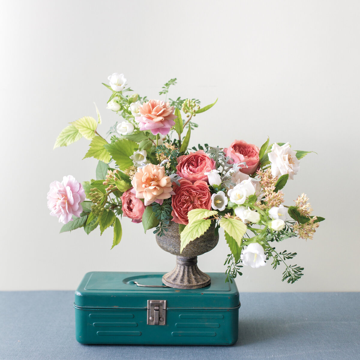 Lush peonies, leaves, and spring flowers in a floral wedding arrangement.