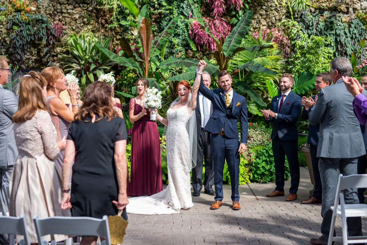 Bride and Groom throwing hands in the air after being announced as husband and wife.