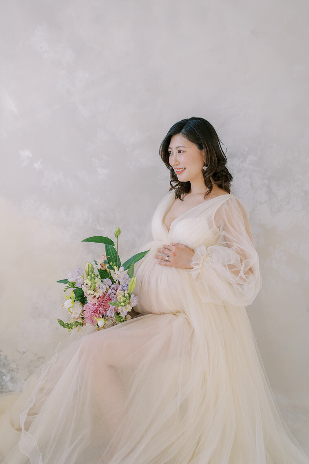 Celebrate pregnancy's grace with an Asian mum of Chinese descent, resplendent in a cream tulle gown, at a Gold Coast maternity shoot