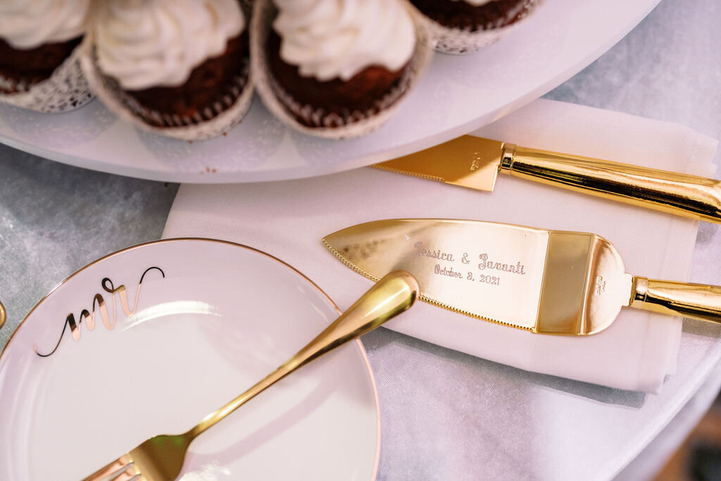 gold serving ware and plates beside cupcakes at a dessert table