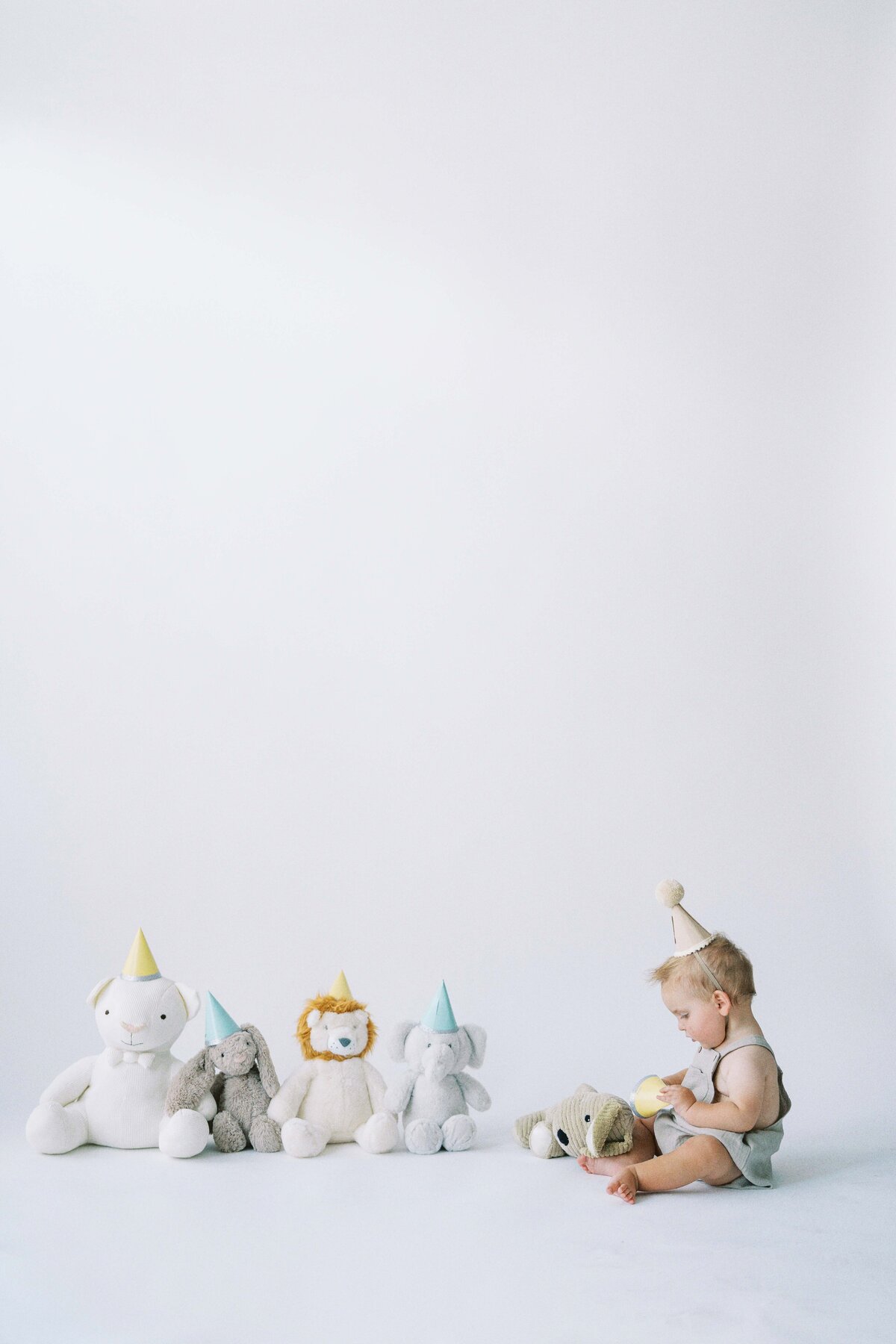 one year old boy playing with stuffed animals
