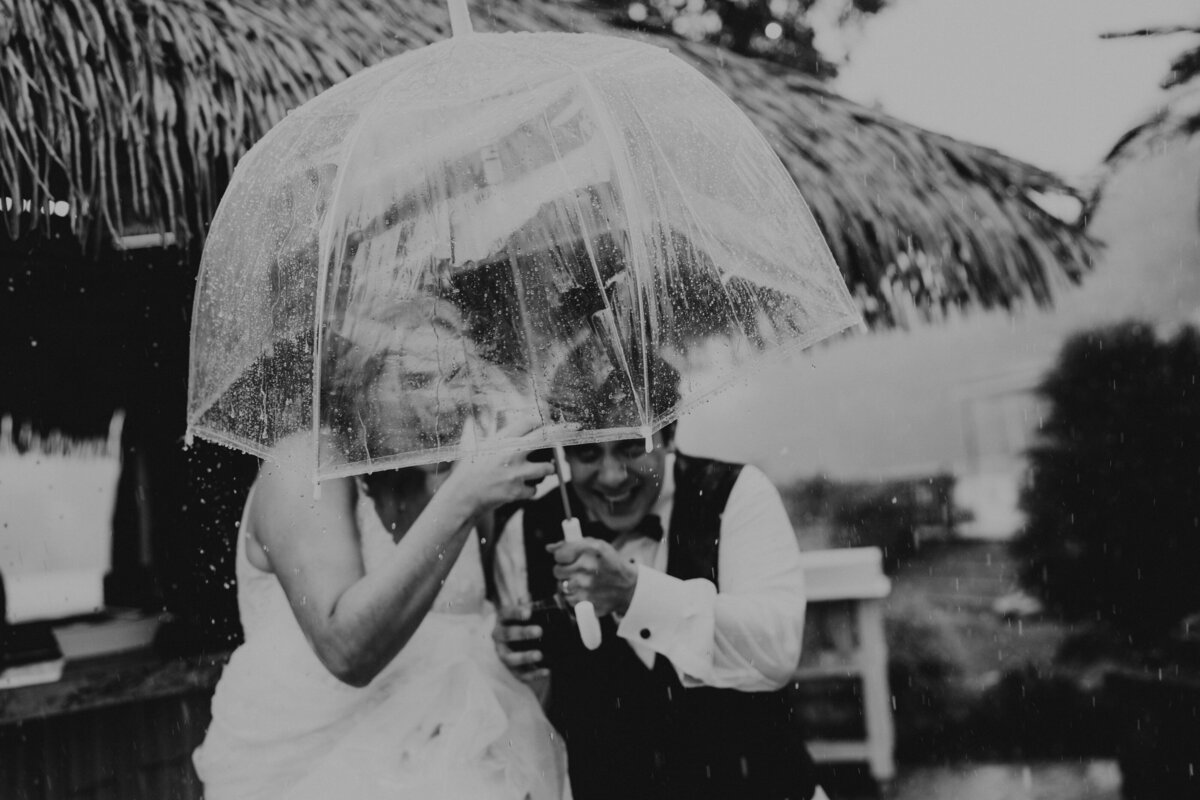 Couple runs through the rain at reception in Geauga County