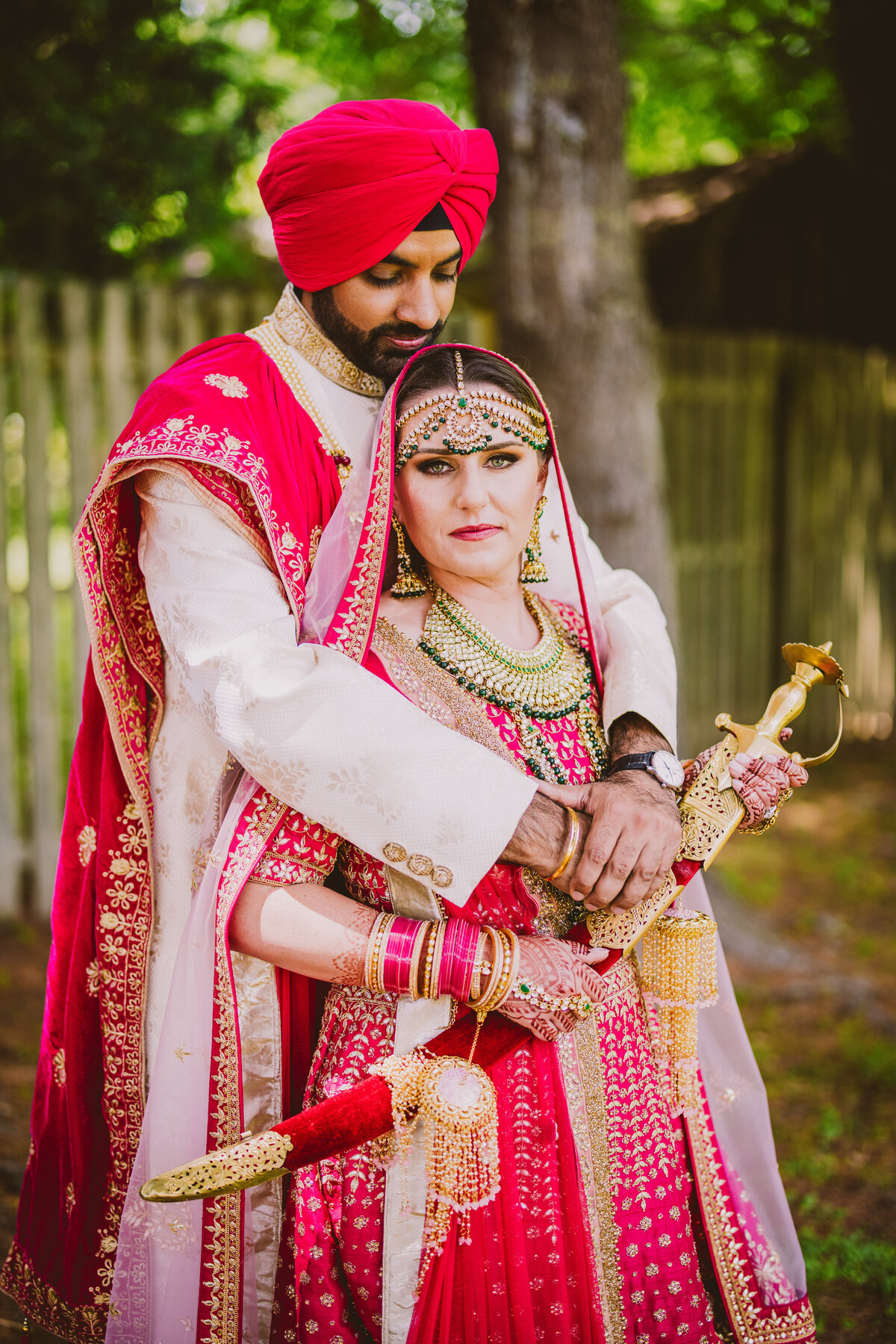 A sikh groom and white bride embrace after the anand karaj wedding ceremony at glen rock gurudwara nj 