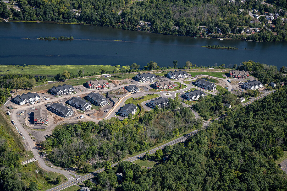 Aerial view of newly built apartment buildings alongside the Mohawk River with new roofs completed by KC Entities Roofing and Siding 