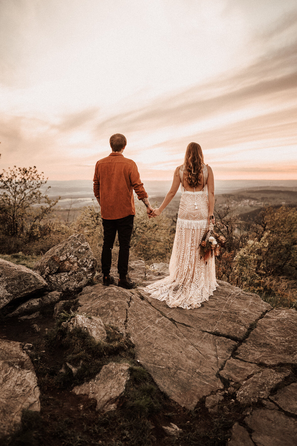 Brautpaar auf einem Felsen bei Sonnenuntergang
