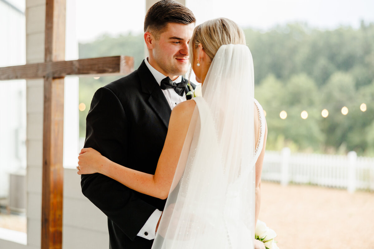 The groom smiling at his bride.