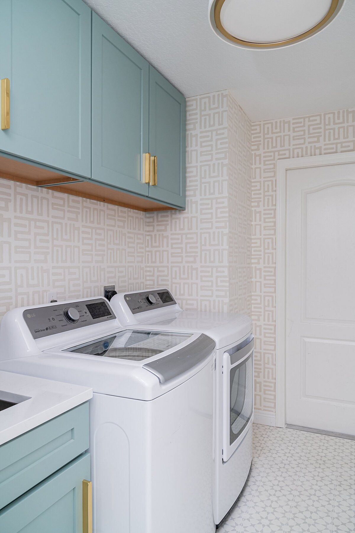 coastal luxury home laundry room with green cabinets and a soft neutral wallcovering full service interior design by Island Home Interiors Lake Nona