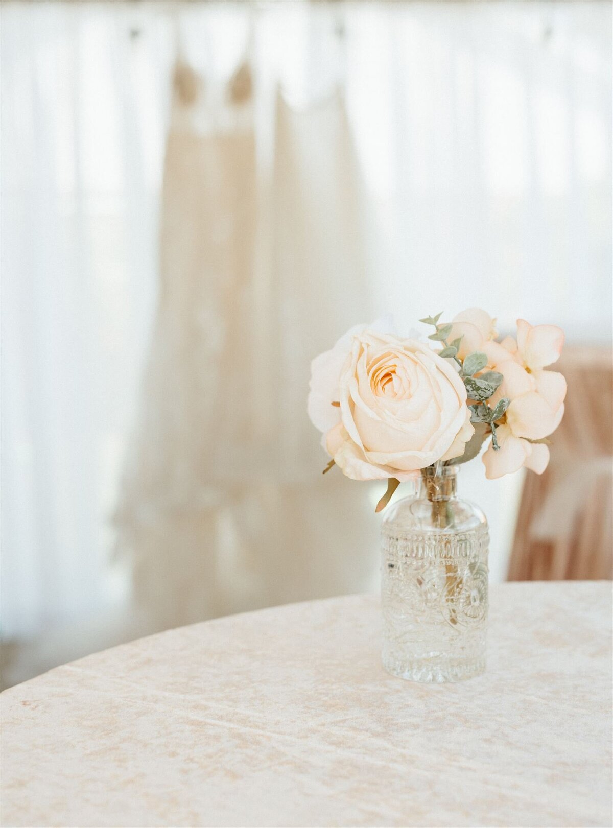flowers with wedding dress in the background