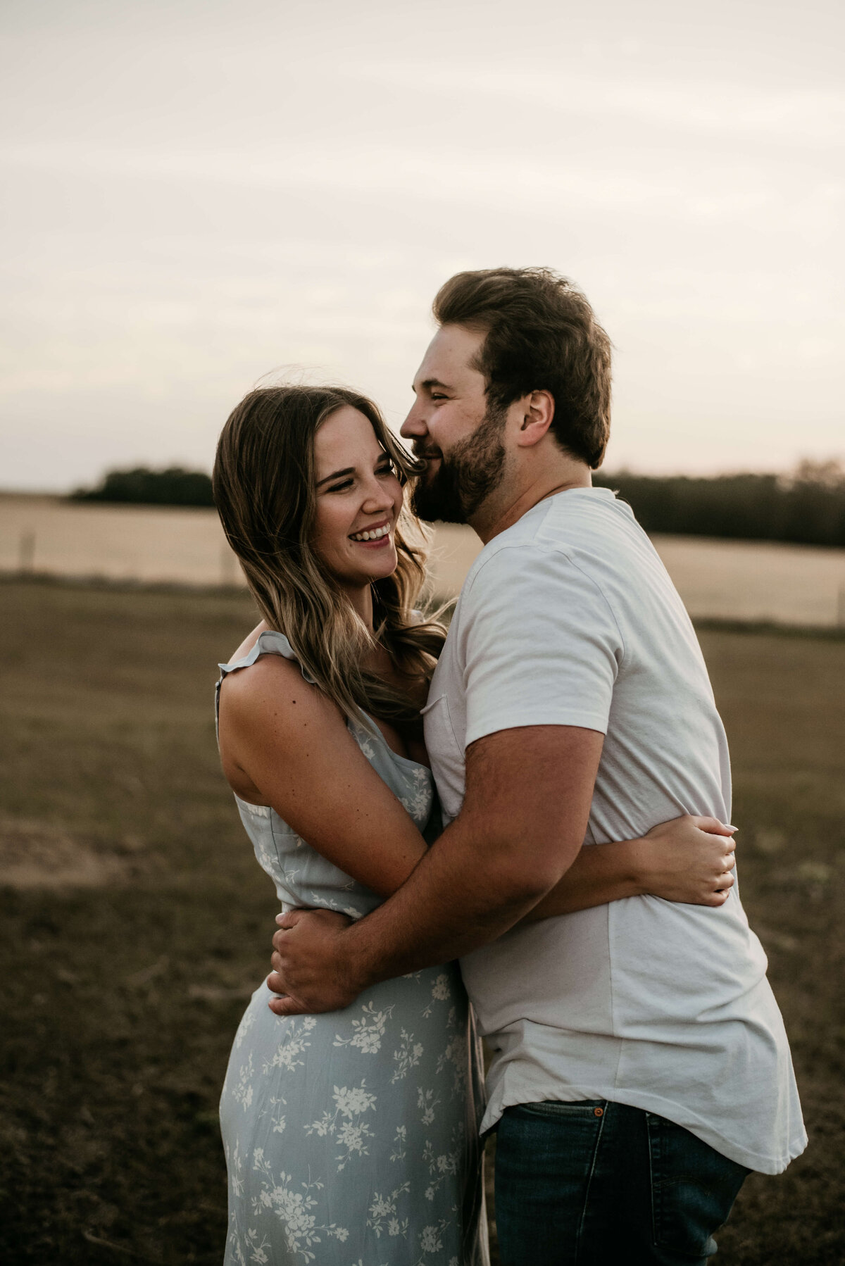 Man hugs his wife in field