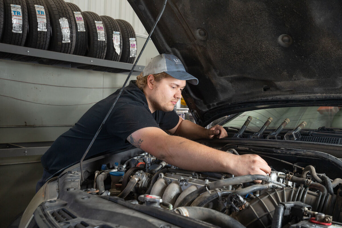 A man is working under the hood of a car