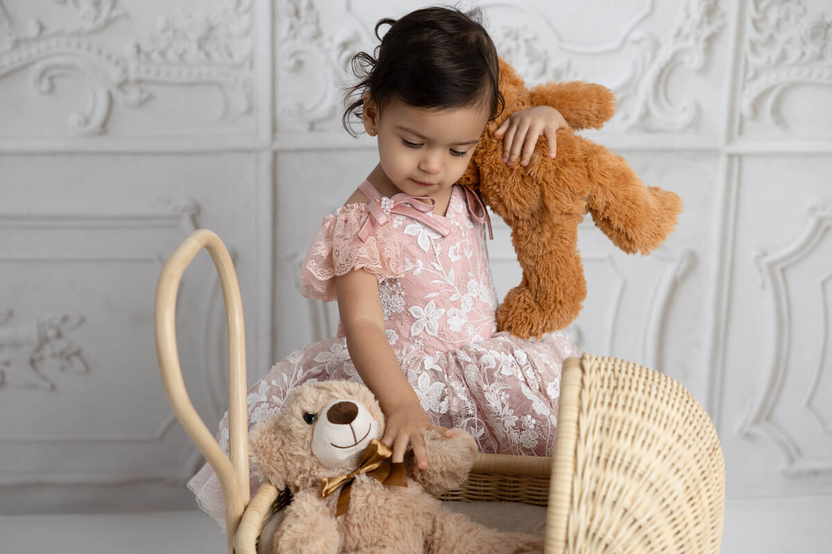 child admiring her teddy bears during photoshoot