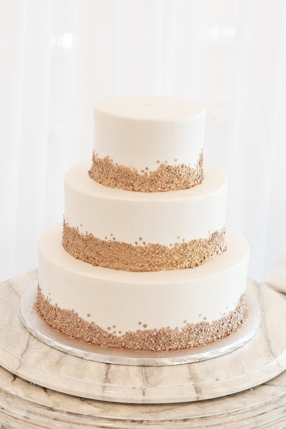 Three-tiered wedding cake with sand sprinkles