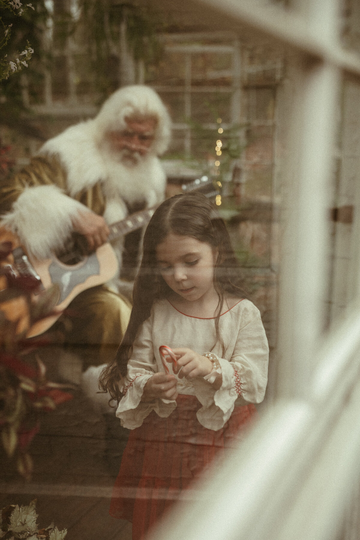 A little girl opening a candy cane at Das Hinterhaus studio in Marietta, GA. 