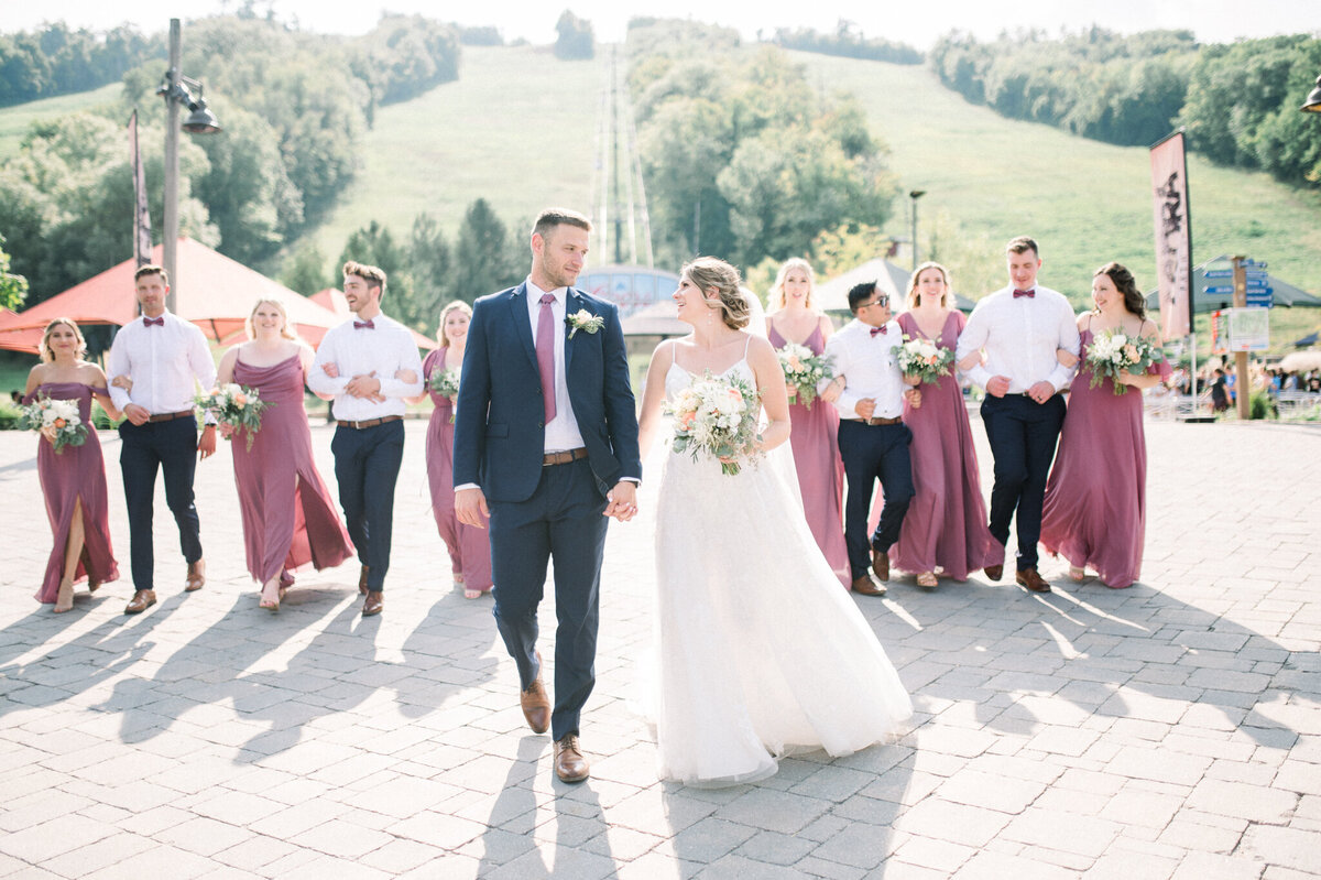 Bride and groom walk ahead of Bridal party captured by Niagara wedding photographer