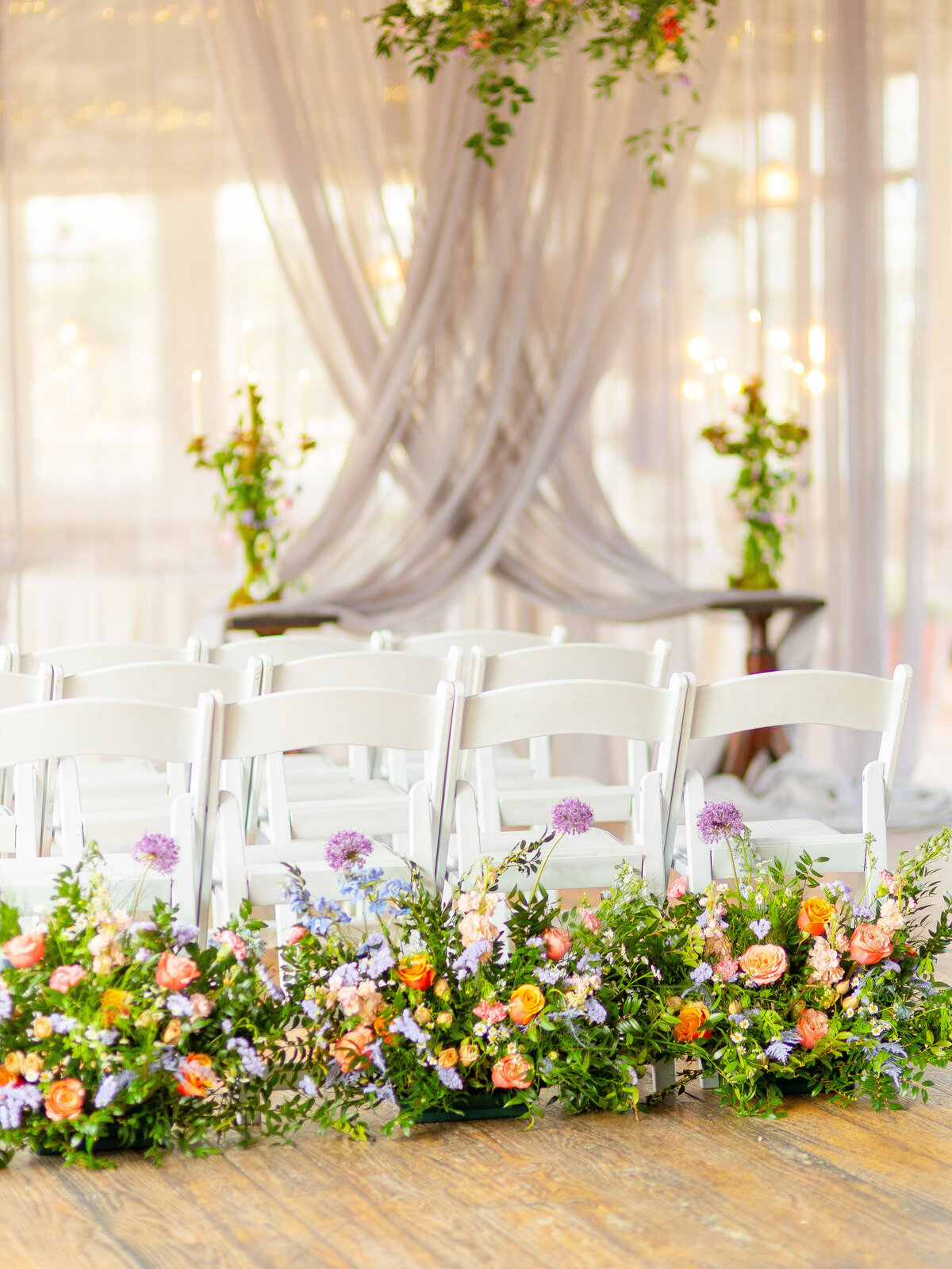 Wedding flowers up against white guests charis