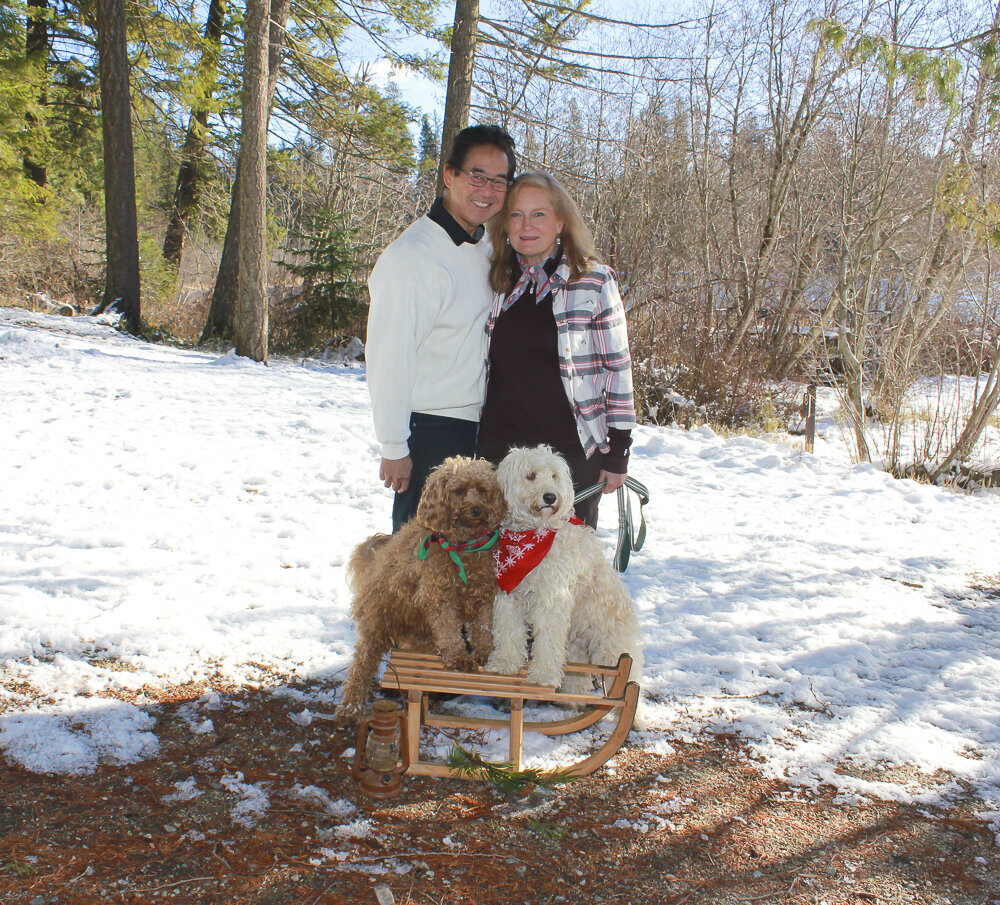 Couple with their dogs standing on a snow sled
