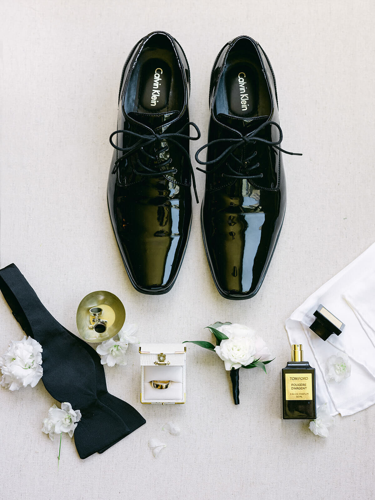 Groom's shoes, bowtie, cologne, and boutonniere details