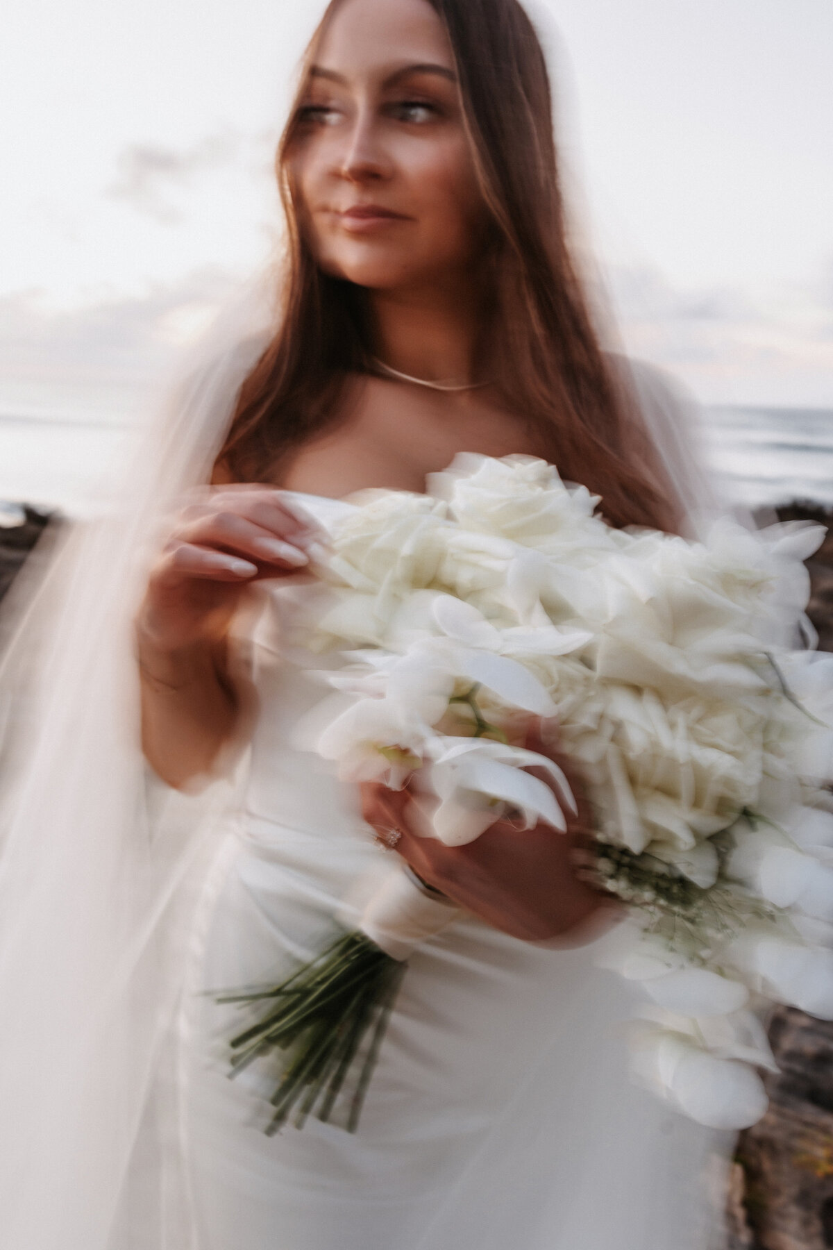 Elopement Photography, slow motion shutter of bride holding her white bouquet looking into the distance