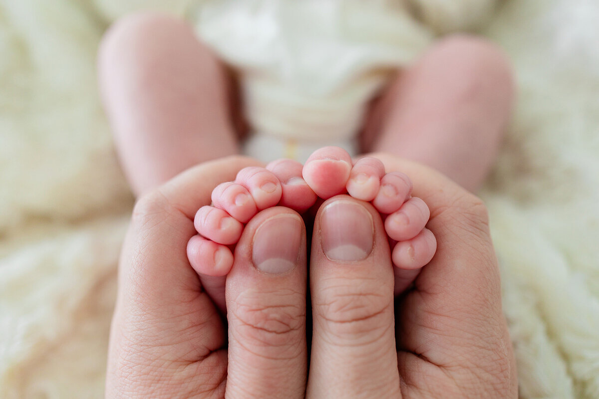dads thumbs with tiny baby toes