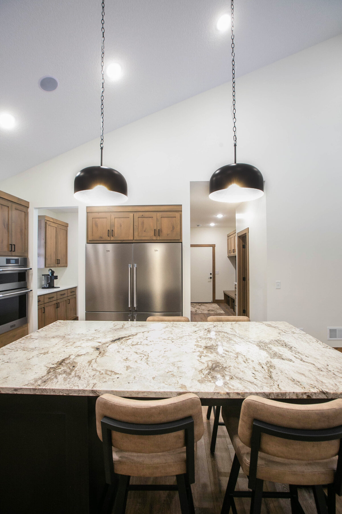 Open kitchen with dark cabinets, large island, and quartz countertops in an Elk River custom home