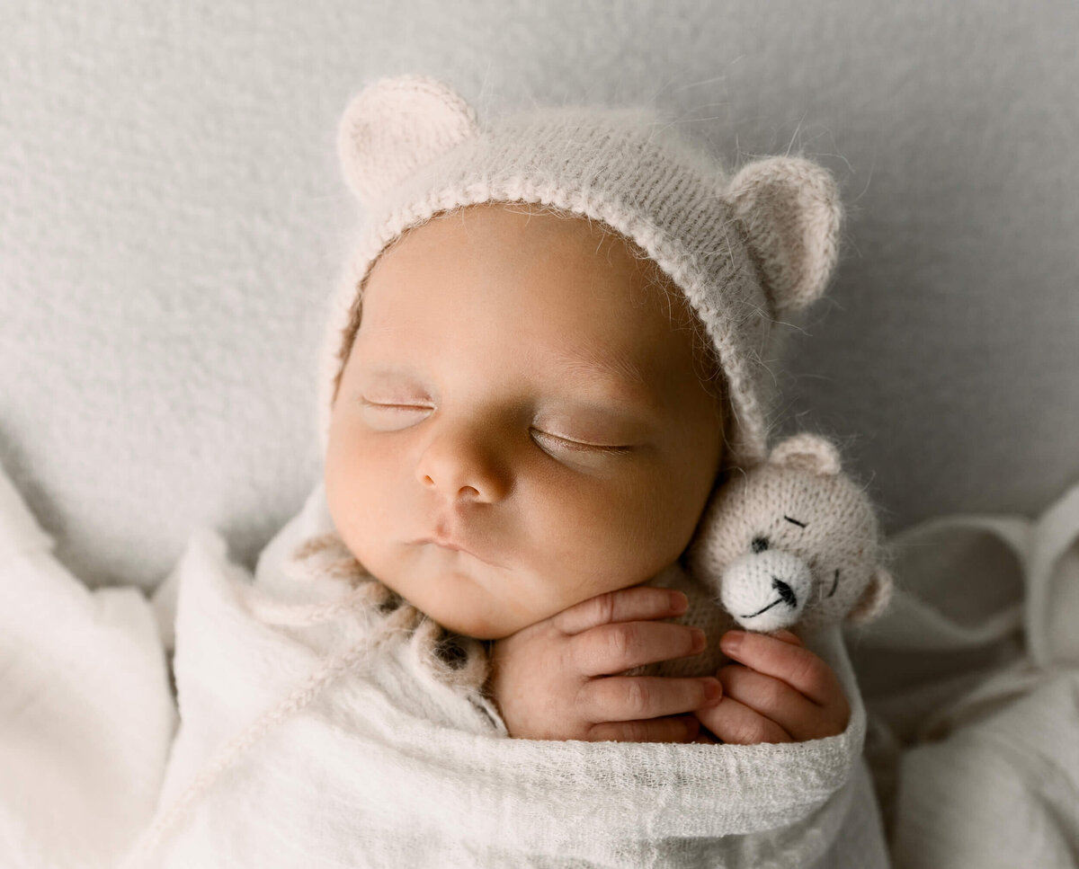 Photo of a baby boy holding a tedding bear in an Erie Pa photography studio