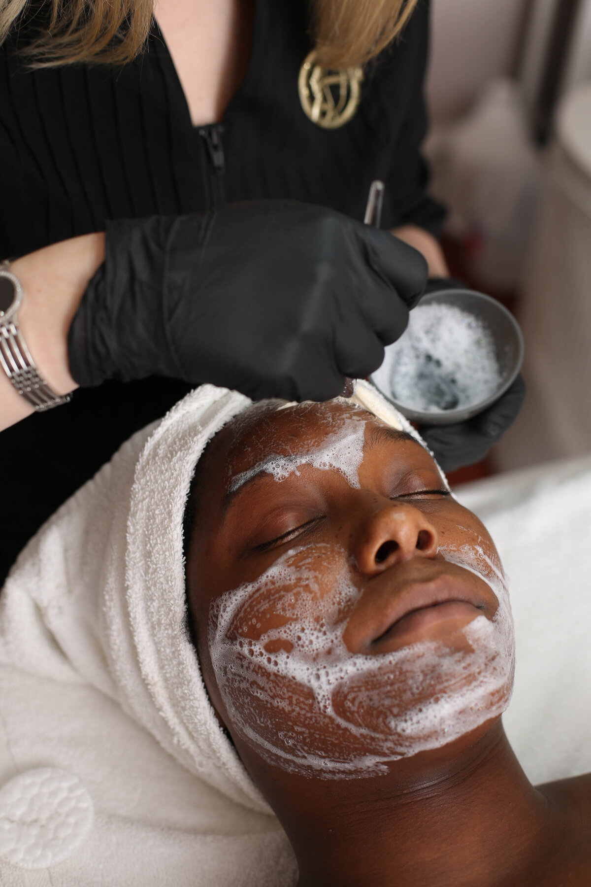 Young African American woman receiving a foam facial