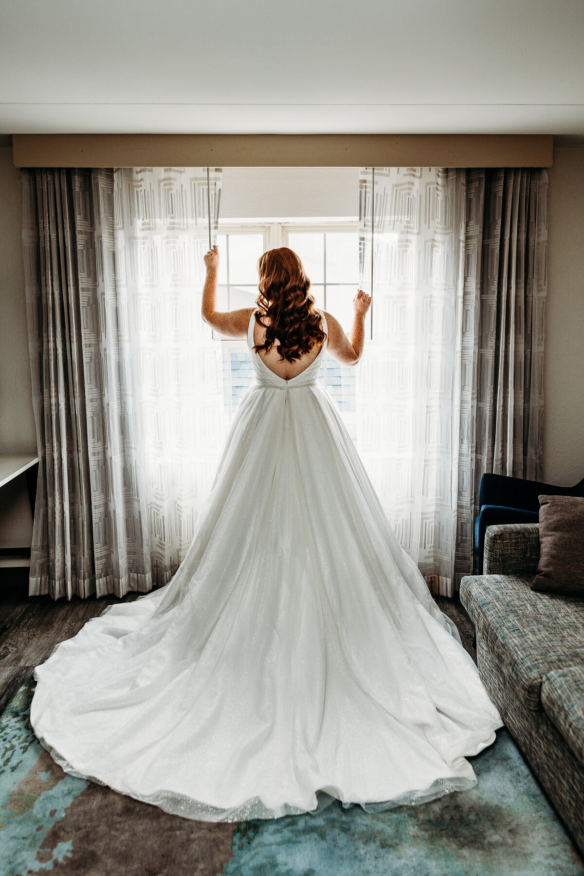 An elegant bridal shot from behind looking out a window.