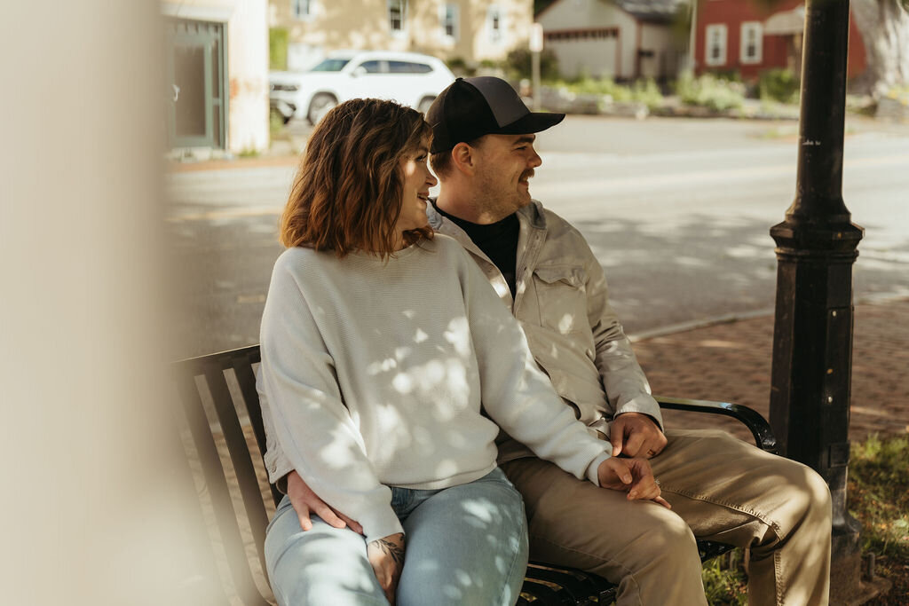 Photo of couple laughing together on bench