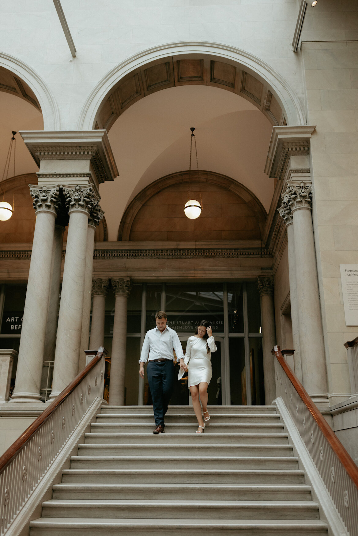 Couple walking through and arched building.
